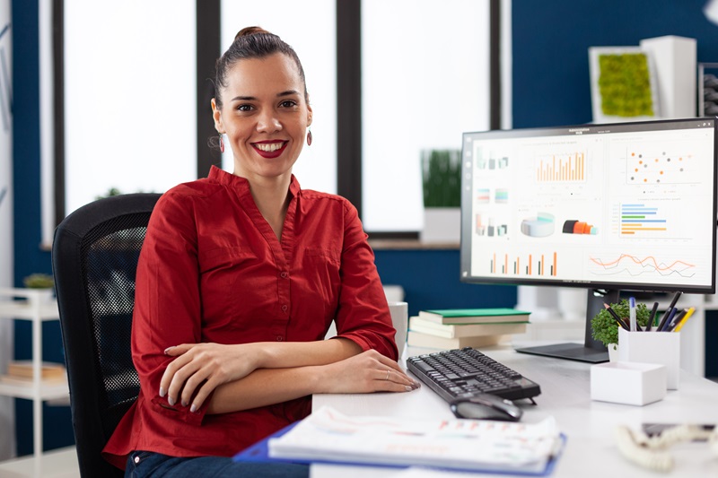 Portrait of business woman in corporate office sitting at desk