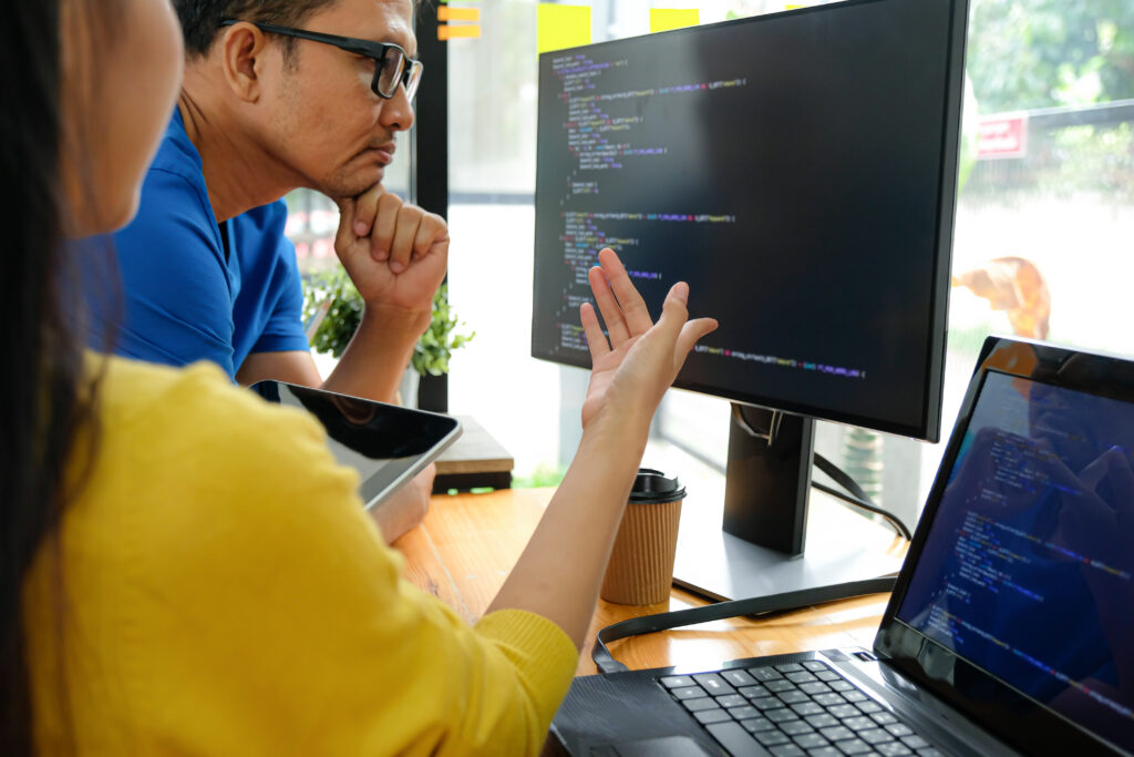 Developers reviewing structured data code on a monitor for dental website schema markup